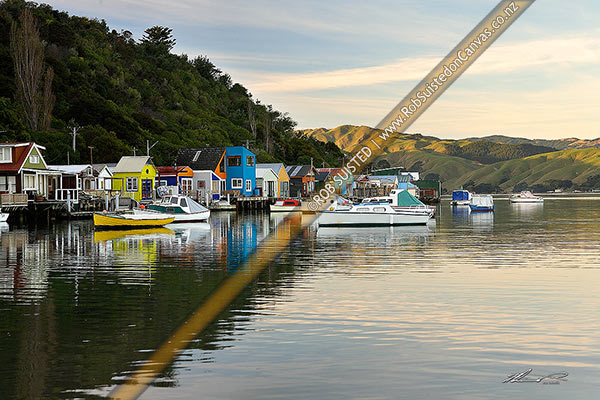 Photo of Colourful Mana boatsheds and boats in the water of Pauatahanui Inlet on a calm evening, Paremata, Porirua City, Wellington Region, New Zealand (NZ)