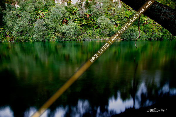 Photo of Evening time exposure of the slow moving Waikato River passing forested banks. Reflections in moody water. Shallow tilt focus, Taupo, Taupo, New Zealand (NZ)
