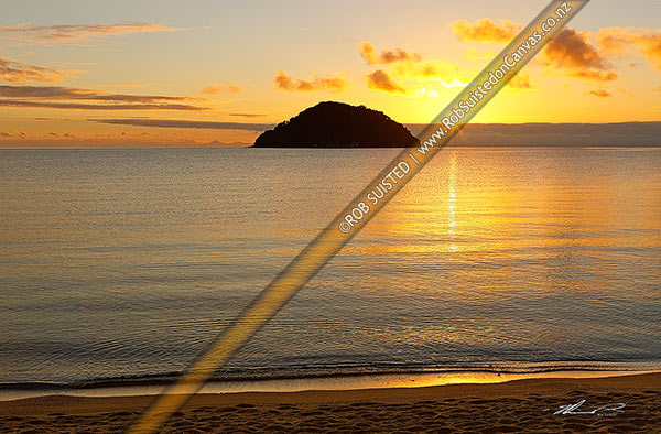Photo of Onetahuti Bay beach sunrise, with sun rising behind Tonga Island, Tonga Roadstead on a beautiful calm summer morning. Golden sand beach, Abel Tasman National Park, Tasman, Tasman Region, New Zealand (NZ)