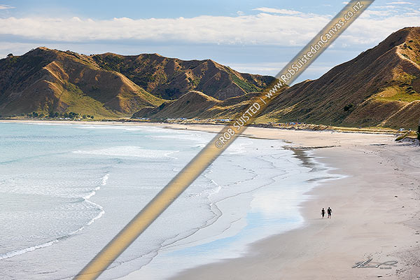 Photo of Kaiaua Bay Beach with people walking on beach, and summer campers in distance, Tolaga Bay, Gisborne, Gisborne Region, New Zealand (NZ)