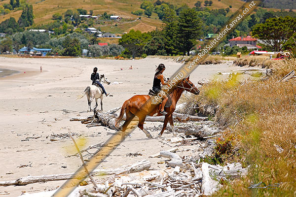 Photo of Horse riding on beach. Young Maori girls riding their horses on the beach sand, Tokomaru Bay, East Coast, Gisborne, Gisborne Region, New Zealand (NZ)