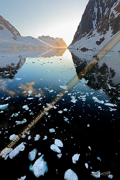 Photo of Lemaire Channel, Antarctica. Perfect reflections at midnight, with brash ice floating under beautiful peaks, Antarctic Peninsula, Antarctica, Antarctica Region, Antarctica