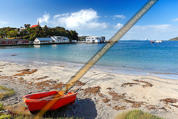 Photo of Halfmoon Bay, and wharf, with a dinghy pulled up at the main town on Stewart Island, Rakiura, Halfmoon Bay (Oban), Stewart Island, Southland Region, New Zealand (NZ)
