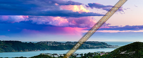 Photo of Sunset over Wellington Harbour, with sunset light colouring clouds and a lone rainfall over Cook Strait and Miramar Peninsula. Panorama, Wellington, Wellington City, Wellington Region, New Zealand (NZ)