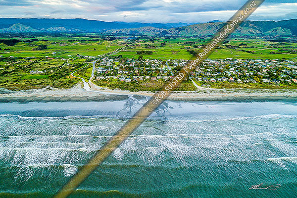 Photo of Te Horo Beach township or village. Aerial view looking over beach to farmland and Tararua Ranges beyond. Mangaone Stream crossing beach, Te Horo Beach, Kapiti Coast, Wellington Region, New Zealand (NZ)