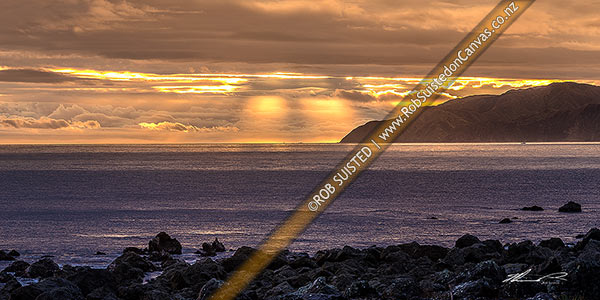 Photo of Wellington South Coast and Cook Strait with spectactular light show at sunset over Sinclair Head (centre). Panorama, Turakirae Head, Hutt City, Wellington Region, New Zealand (NZ)