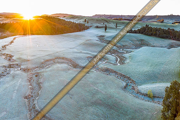 Photo of Balls Clearing Scenic Reserve and Clifton Conservation Area at dawn with heavy frost, as sun rises over hill. Headwaters of Mangatutu Stream. Aerial view, Puketitiri, Hastings, Hawke's Bay Region, New Zealand (NZ)
